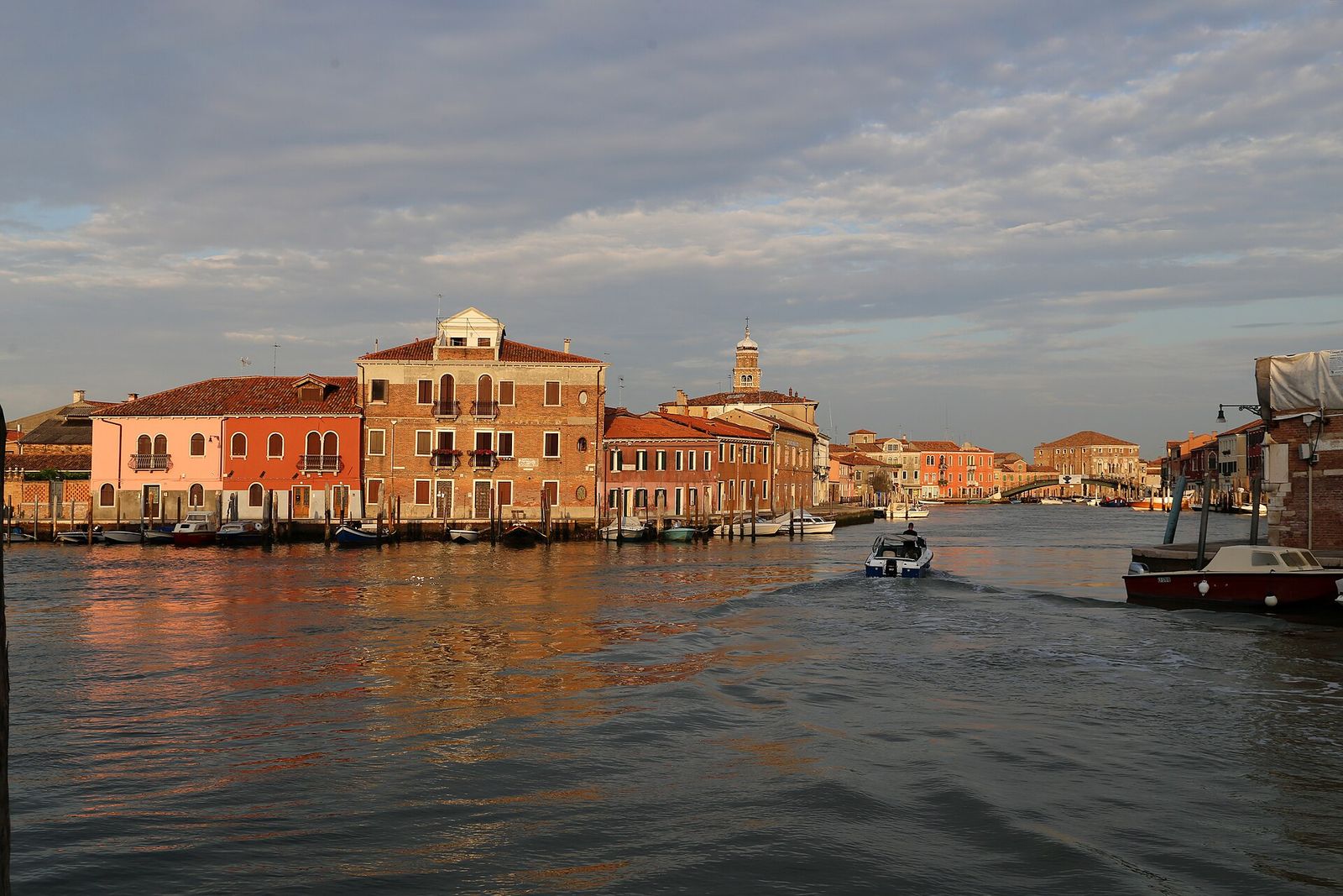 Murano’s Grand Canal in low evening sun, with brick and pastel houses along the water
