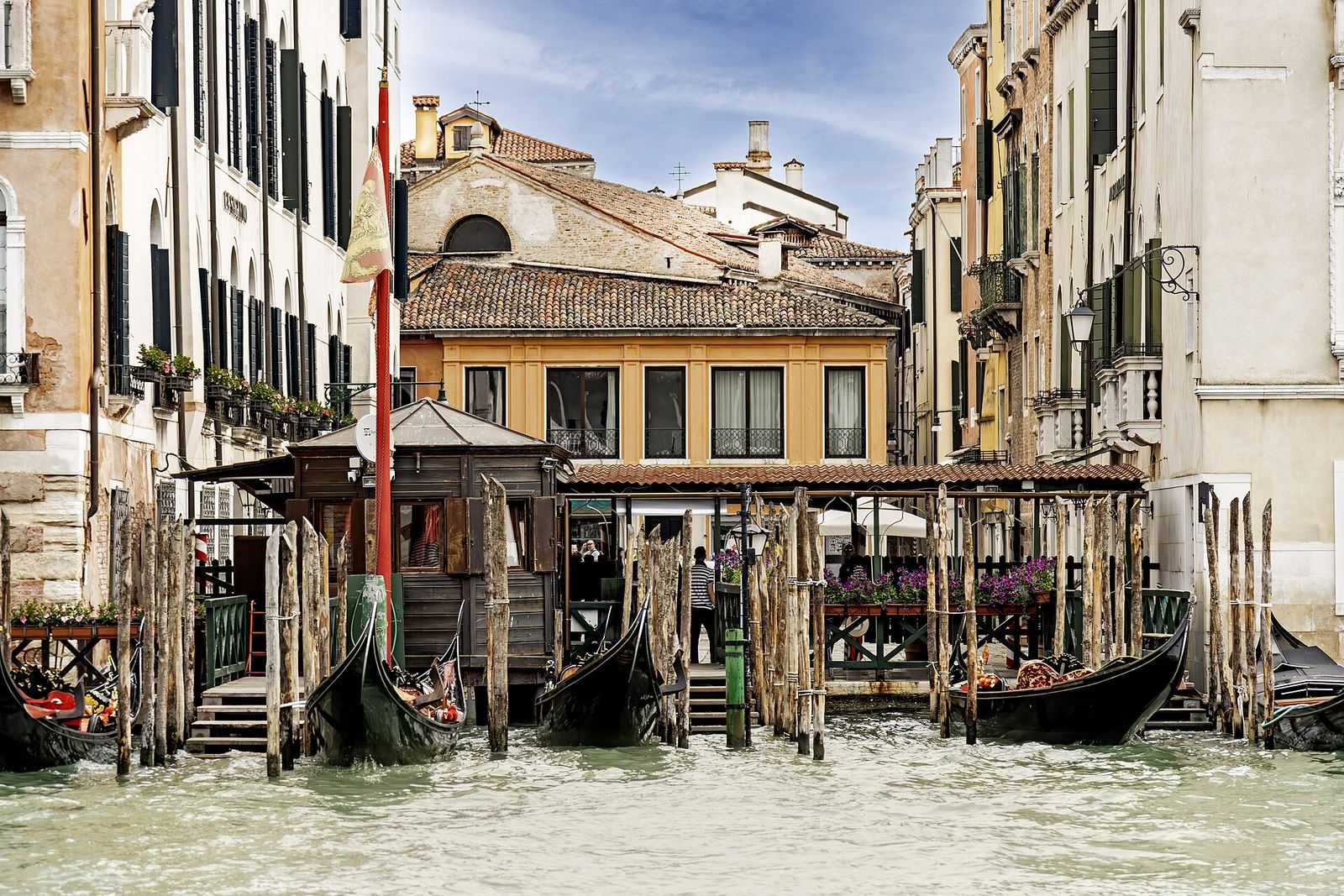 Gondolas waiting at the Santa Sofia traghetto landing on the Grand Canal, beside a small wooden shelter